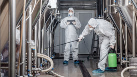 men in hazmat suits cleaning plant