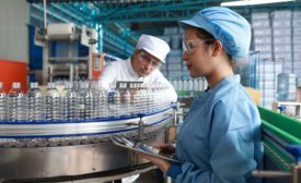 people in uniform working at bottling plant