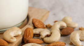 cashews and almonds next to jar of milk