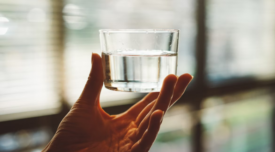 hand holding small cup of water