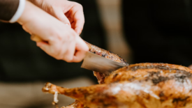 person carving a turkey