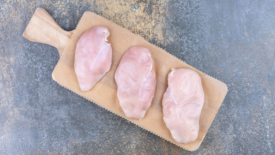 raw chicken breast on wooden board