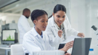 women in white coats conferring